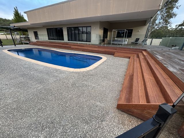 Poolside hardwood staircase and deck by Curtain Constructions